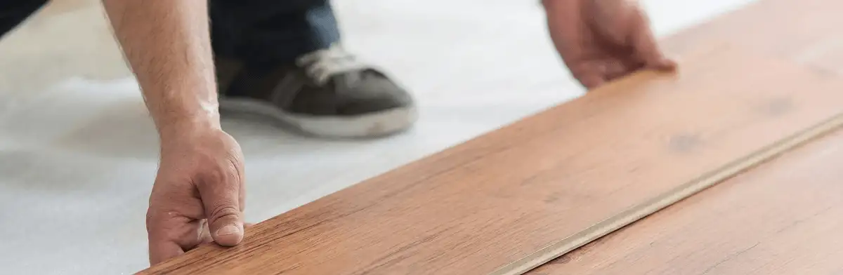 A professional installing laminate flooring in Lakewood, CO